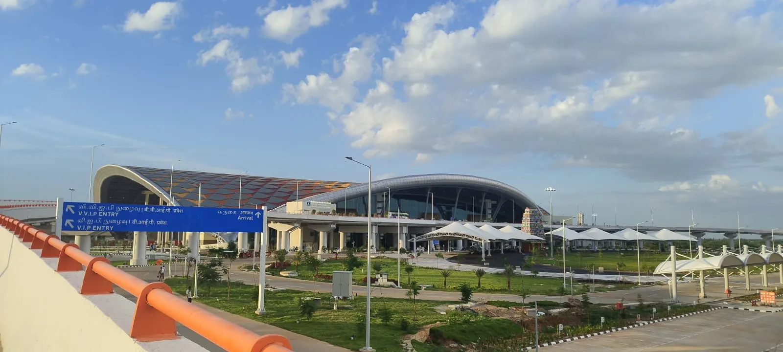 Landside view of Tiruchirappalli International Airport’s June 2024 integrated terminal, with the gopuram-inspired roof, Arrival and VVIP Entry road signs, and canopy-covered kerb.