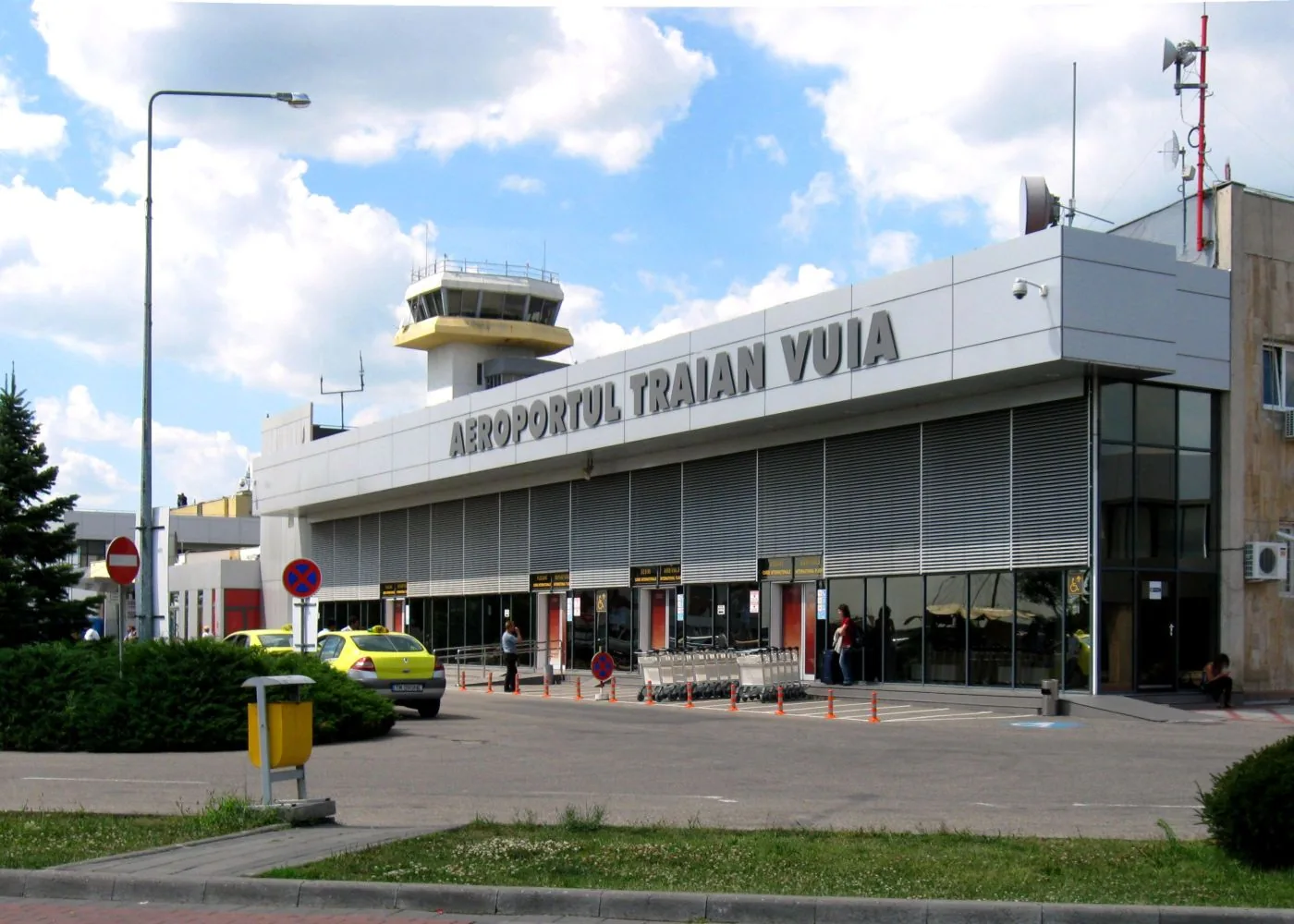 Older terminal building at Timișoara airport with the 'Aeroportul Traian Vuia' sign and rooftop tower