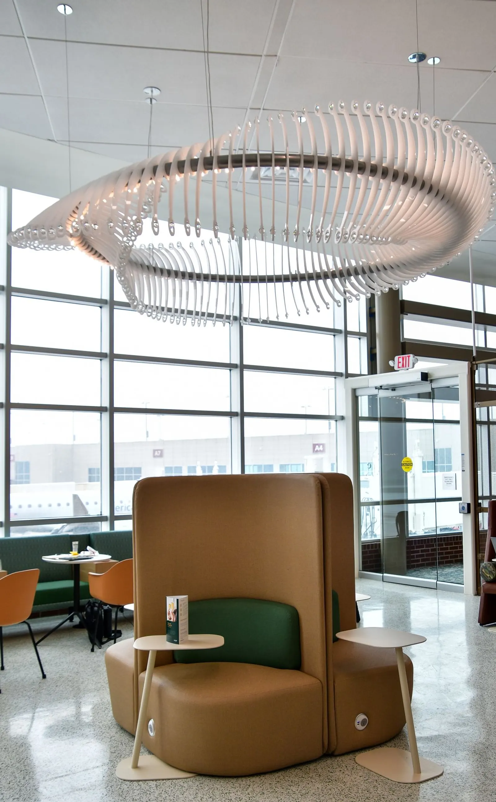High-backed privacy seating pod with runway views in the Escape Lounge at Northwest Arkansas National Airport (XNA).
