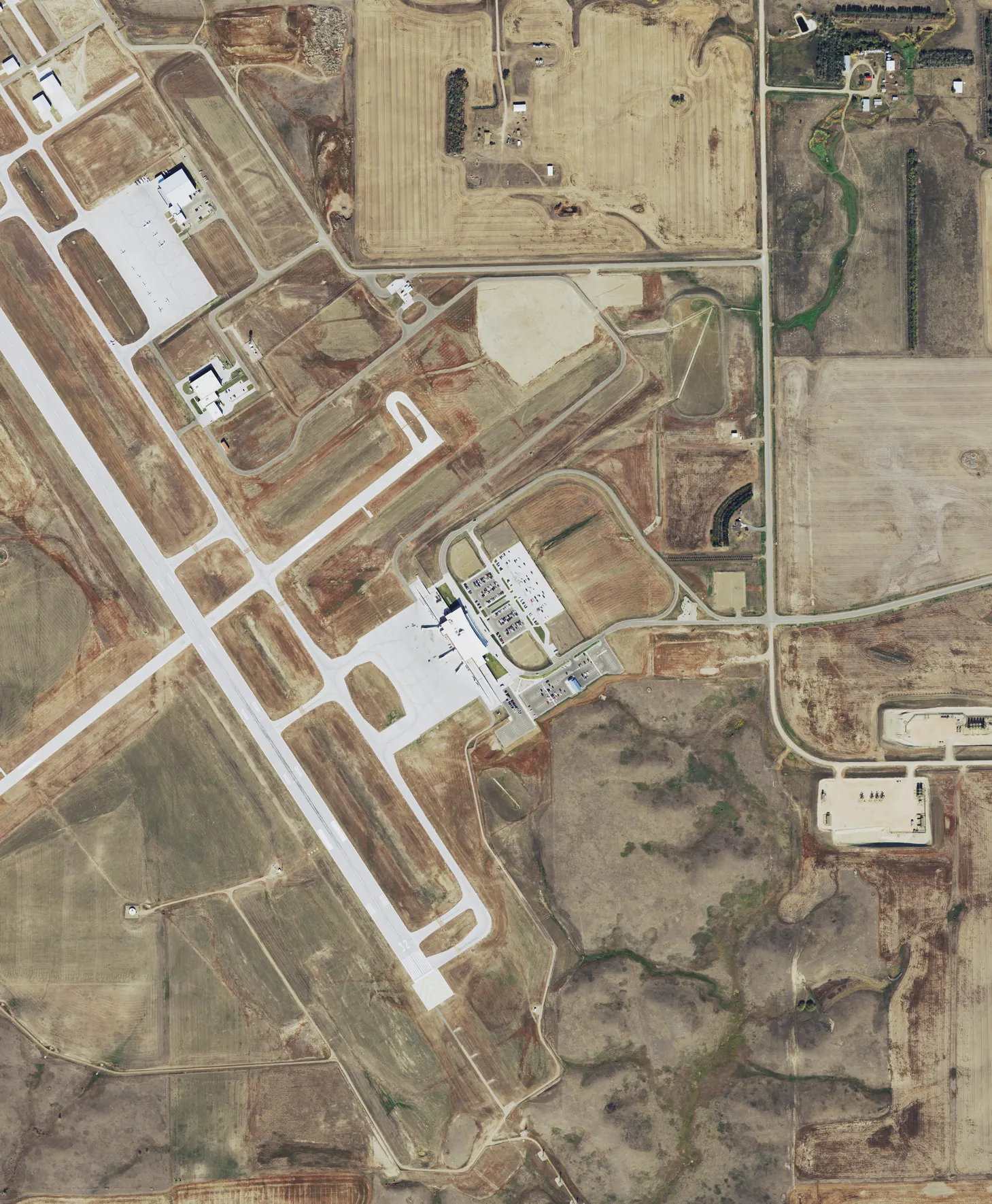 Cropped September 2021 NAIP aerial of Williston Basin International Airport (XWA) showing the Sloulin Terminal, parking lot, and main runway.