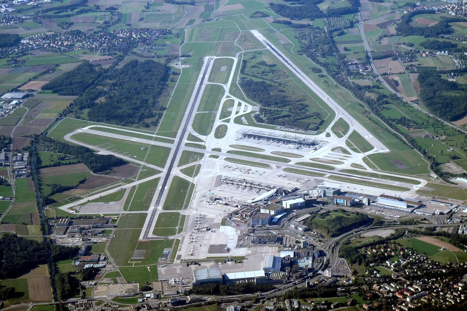 Aerial view of Zurich Airport terminals, piers and runways from the south.